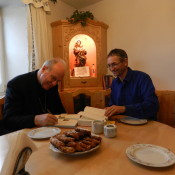 Kardinal Christoph Schönborn bei uns in der Stube beim signieren der Bibel und seines Gastgeschenkes